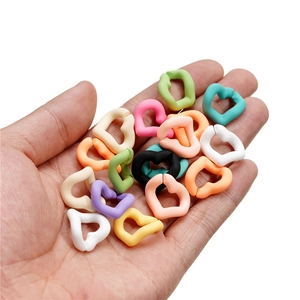 Colorful heart-shaped acrylic chain links for DIY jewelry making shown on hand
