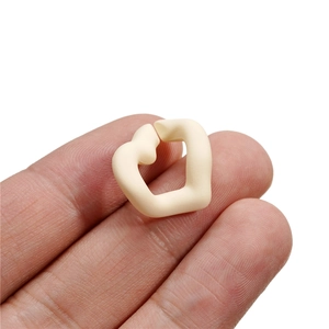 Matte cream acrylic chain links with geometric hollow design held between fingers
