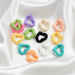 Colorful acrylic heart shaped links in macaron colors on soft white silk fabric