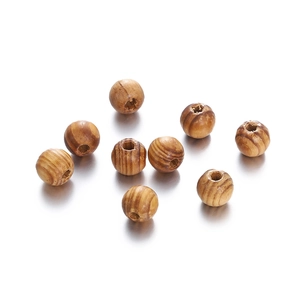 Macro shot of maple wood beads with natural grain and pre-drilled holes for DIY jewelry