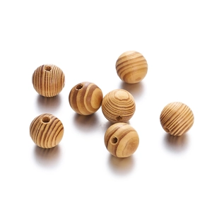 Macro detail of natural maple wood beads showing clear annual ring patterns and drill holes