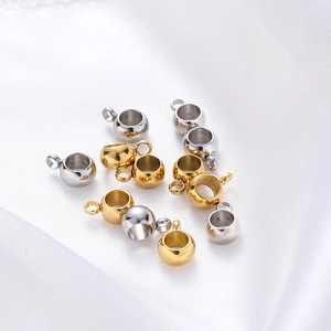 Gros plan d'attaches de pendentif en acier inoxydable or et argent sur soie blanche