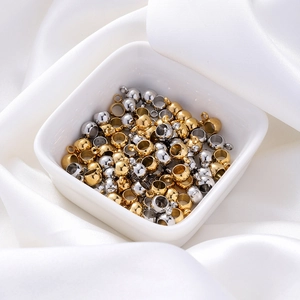 Gros plan de perles d'espacement en or et argent avec boucles dans un bol en céramique
