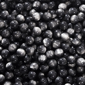 Macro shot of black cat-eye resin round beads with silver sheen for DIY jewelry making