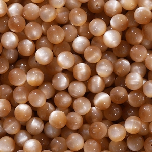 Macro shot of champagne cat eye resin beads with smooth texture for jewelry making