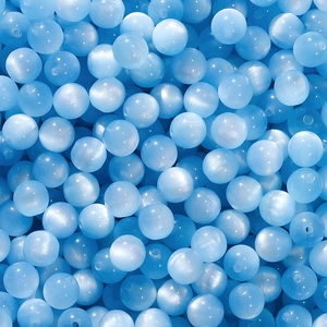 Macro detail of sky blue resin cat eye beads for DIY handmade jewelry crafting