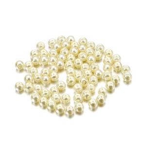 Macro shot of ivory white glass imitation pearls with glossy finish for DIY jewelry crafts