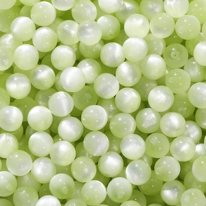 Macro shot of light green resin beads with cat eye effect for DIY jewelry making