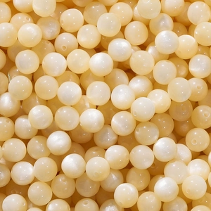 Macro shot of creamy resin faux cat eye round beads with pre-drilled holes for jewelry DIY
