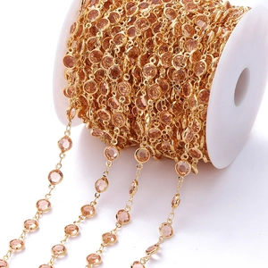 Detail van 1m vergulde ketting met champagne zirkoon facetten op een witte spoel
