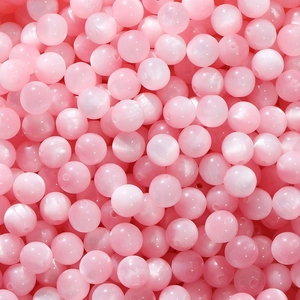Macro shot of pink resin cat eye round beads for handmade jewelry and necklaces