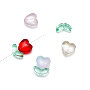 Dettaglio di perline in vetro a forma di cuore e foglia con fori per gioielli fai-da-te
