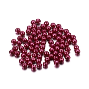 Macro detail of glossy dark red 4mm glass pearl beads with pre-drilled holes for DIY jewelry