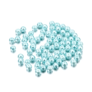 Detailed view of light blue 4mm glass pearl beads scattered on a white background