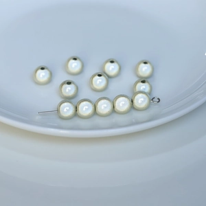 Macro shot of ivory pearlescent round beads for DIY jewelry and beaded crafts