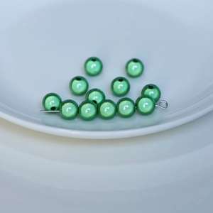 Macro detail of green laser reflective beads for DIY jewelry and phone chain making