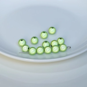 Macro detail of light green pearlized beads with laser finish and center hole structure