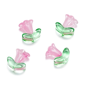 Macro shot of glass tulip and leaf beads for DIY jewelry with pink and green finish