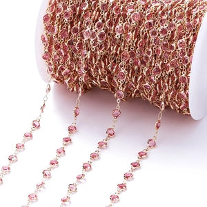 Detail van roségouden ketting met roze zirkoon op een witte spoel voor sieraden maken
