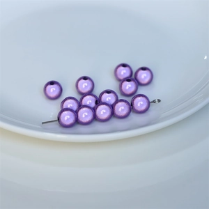Macro shot of 6-8mm purple pearlescent DIY beads for jewelry making in a white ceramic dish