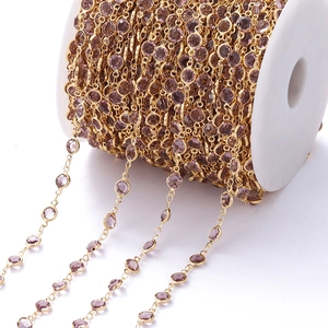 Detail van de vergulde ketting op rol met paarse zirkoon voor DIY sieraden maken