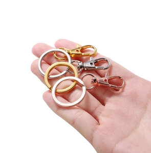 Metall-Karabinerverschluss mit Schlüsselringen in Gold, Silber und Roségold in der Hand