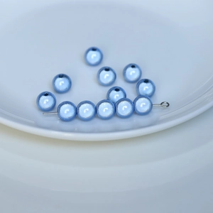 Dettaglio macro di perle in acrilico azzurro perlato con fori per la creazione di gioielli