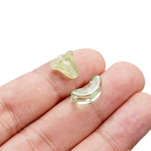 Green glass flower and leaf beads for DIY jewelry making shown on fingertip
