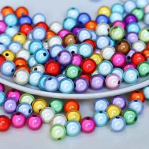 Vista macro di perline iridescenti colorate con fori per la creazione di gioielli DIY