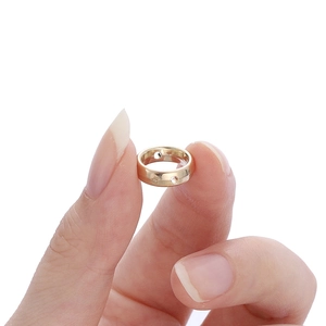 Gouden minimalistische ring met parelframe vastgehouden op een witte achtergrond