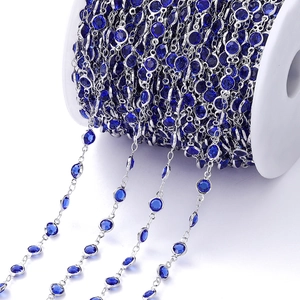Detail van 1m blauwe zirkoonketting met zilveren koperen schakel op een spoel