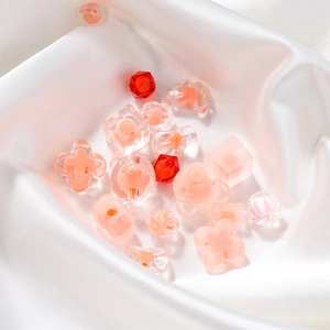 Mixed pink acrylic beads including butterfly and bear shapes on elegant white silk fabric
