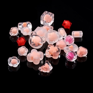 Macro view of assorted frosted acrylic beads in heart, bear, and flower shapes for DIY jewelry