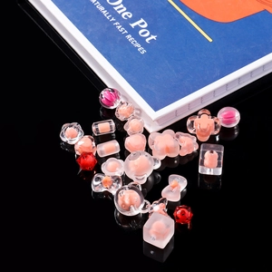 Close-up of frosted acrylic DIY beads in bear and flower shapes on reflective surface