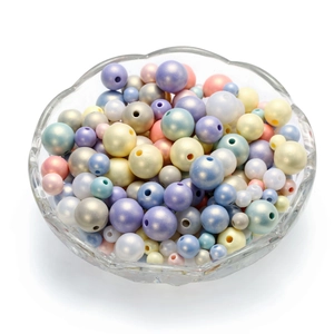 Detail of colorful macaron acrylic pearl beads in a glass bowl for DIY jewelry making