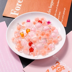 Macro shot of assorted warm-toned acrylic matte beads in heart and bear shapes for DIY