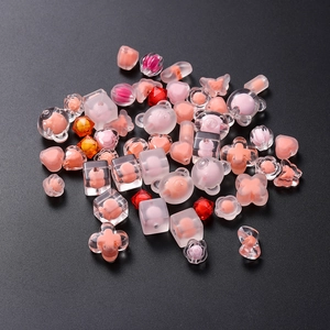 Detailed view of assorted pink acrylic beads in bear, heart, and flower shapes for DIY jewelry