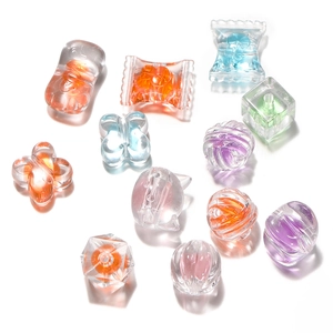 Macro view of colorful acrylic candy beads in heart and butterfly shapes for DIY crafts
