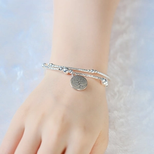 Dettaglio del bracciale a doppio strato in argento con ciondolo albero della vita