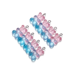 Macro view of gradient pink and blue resin bear charms with silver metal rings for DIY jewelry