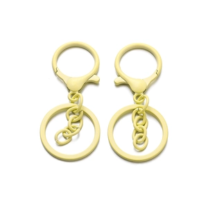 Dettaglio di due portachiavi giallo chiaro opaco con moschettoni e anelli metallici
