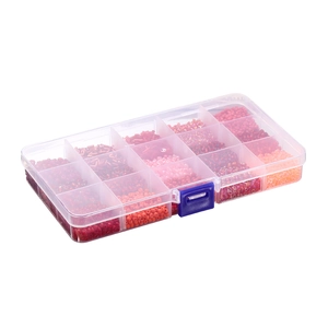 Detailed view of 15-compartment box with red and pink glass beads for DIY jewelry making