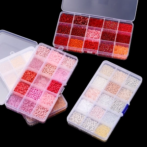 Macro detail of colorful glass seed beads and tube beads set in a 15-grid storage box
