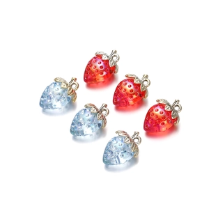 Makroaufnahme von 6 facettierten Erdbeer-Anhängern aus Acryl in Rot und Blau für DIY-Schmuck