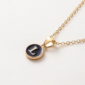 Détail du pendentif lettre L dorée avec émail noir sur une fine chaîne à maillons