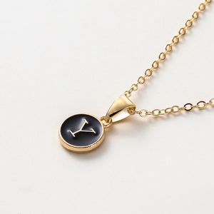 Détail d'un collier lettre Y doré de 52cm avec émail noir sur une fine chaîne à maillons