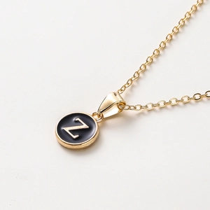 Vue détaillée d'un collier doré avec un pendentif en émail noir et la lettre Z
