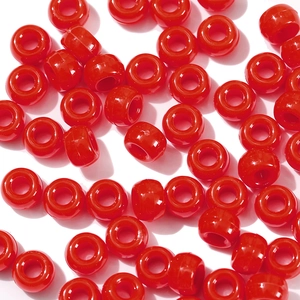 Macro detail of glossy red acrylic large hole pony beads for DIY jewelry making