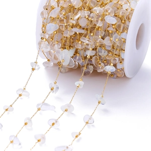 Macro shot of natural crystal chips and golden square beads on a DIY jewelry spool