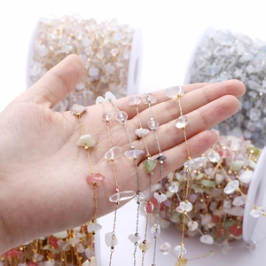 Detail of colorful natural stone gravel chain for DIY jewelry making with metallic links